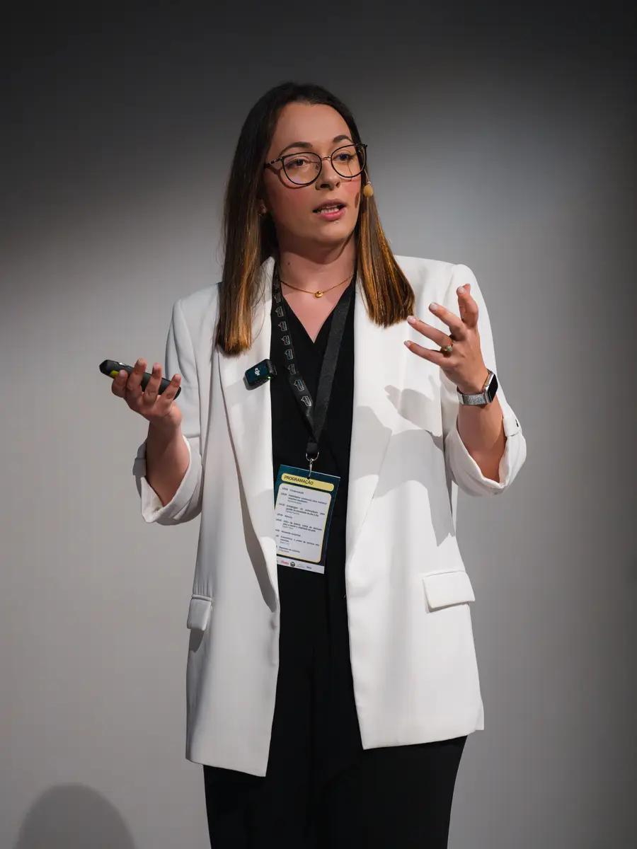Adriana Bugalho em palco, de microfone na lapela, durante palestra na ANJE