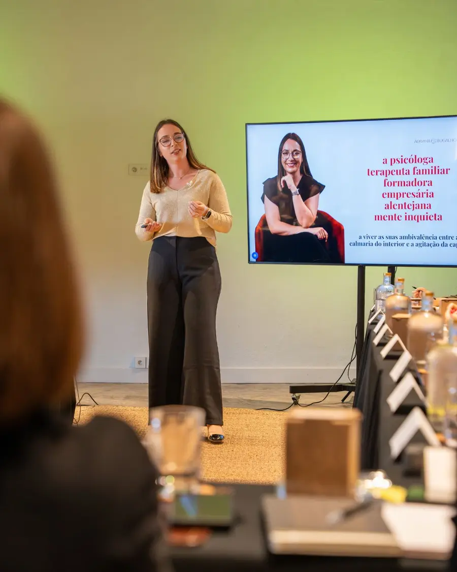 Adriana Bugalho a apresentar uma formação a um grupo sentado à mesa